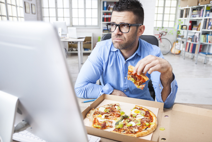 Mann isst Pizza und ist frustriert